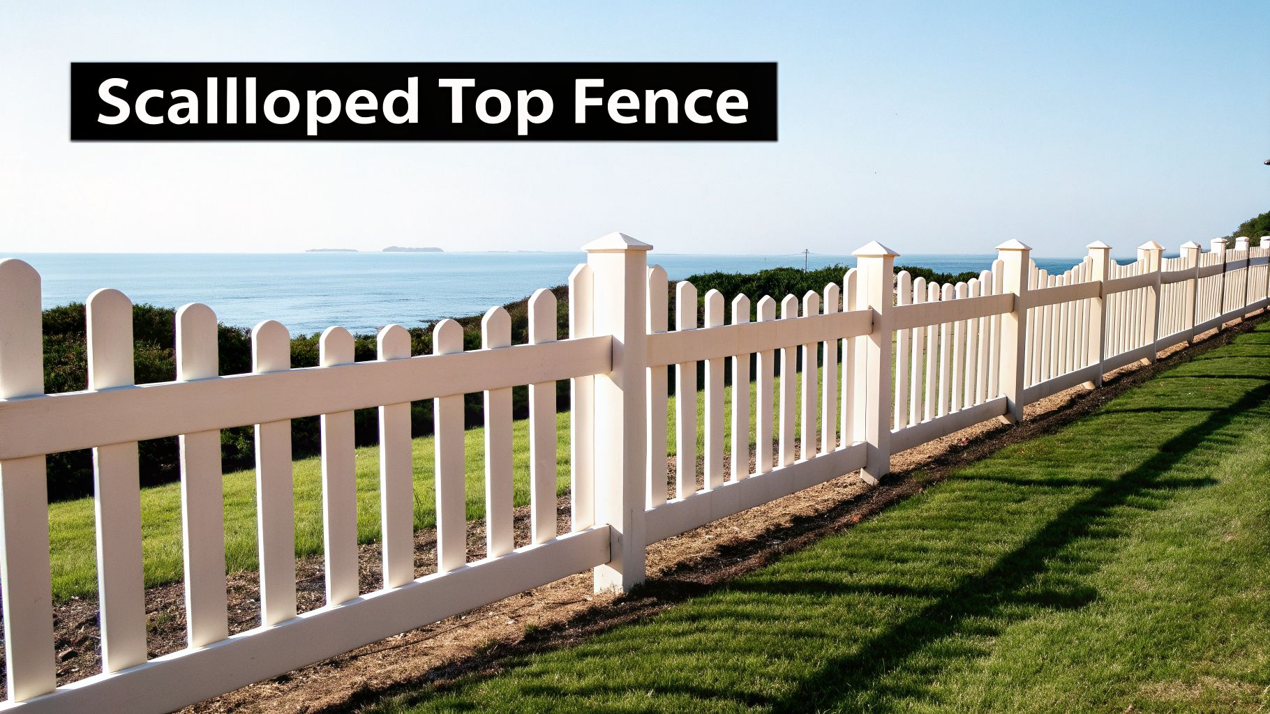 A long white scalloped top picket fence runs along a green lawn overlooking the ocean.